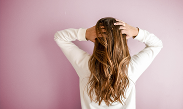 髪をかき上げる女性の画像